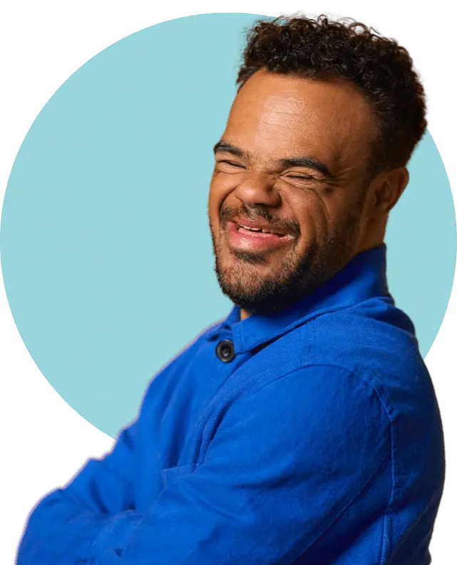 Man with down syndrome smiling at the camera with arms crossed